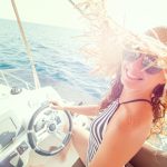 beautiful young woman enjoys relaxing on a yacht at sea
