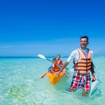 Father with his children kayaking at tropical ocean