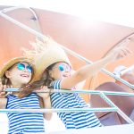 Two little girls enjoying a holiday on a yacht in the sea