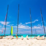 Group of catamarans with colorful sails on Caribbean beach