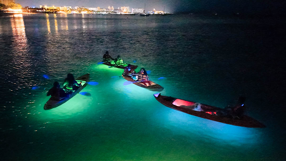 LED night kayaks glowing on calm water during an evening tour in Aruba