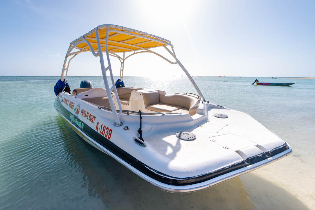 Come & Enjoy private charter boat moored in shallow water in Aruba